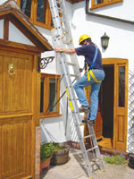Engineer climbing secured ladder whilst attached via rope, rope grab & harness